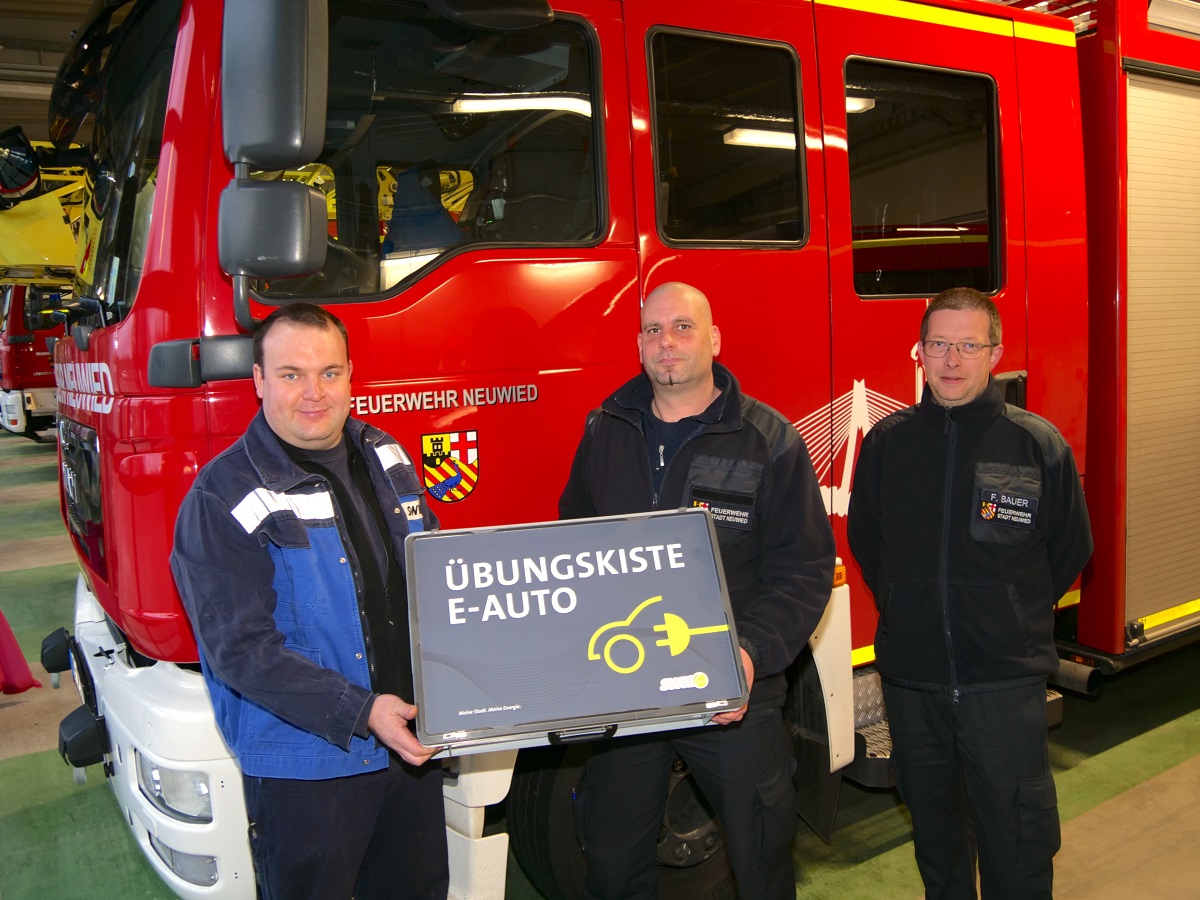 SWN-Werkstattleiter und Feuerwehrmann Johannes Kirst bergab die "bungskiste E-Auto" an Wehrleiter Kai Jost und seinen Stellvertreter Florian Bauer. (Foto: Gerd Neuwirth/SWN)