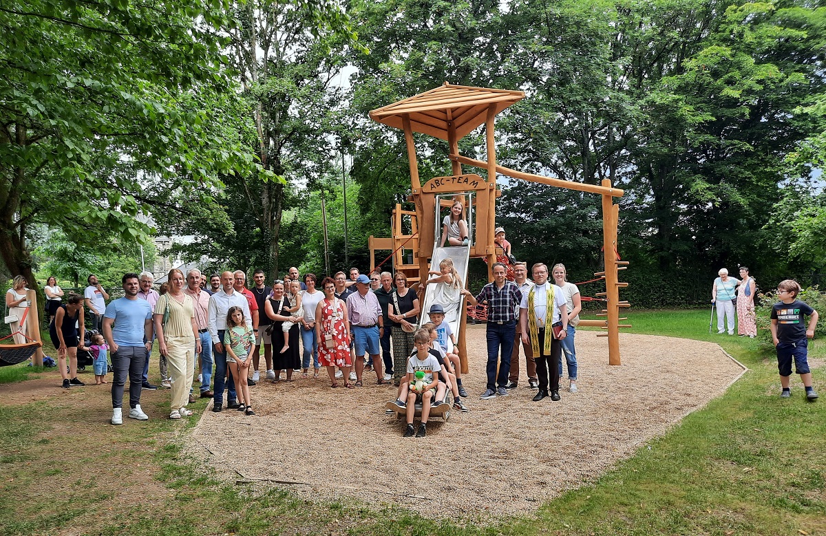 Ortsbrgermeister Thomas Schmidt stellte sich gemeinsam mit Pfarrer Dominik Schmitt und den weiteren Besuchern der Einweihungsfeierlichkeiten zum Erinnerungsfoto im neuen "Kinder-Spieleparadies" auf. (Foto: Rolf Schmidt-Markoski)