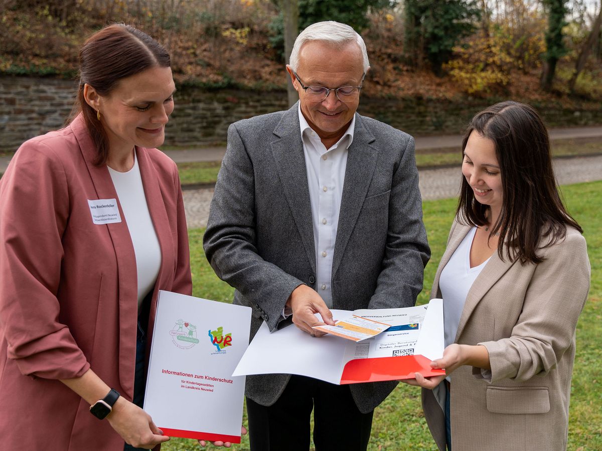 Mit Kreis-Netzwerkkoordinatorin Kindeswohl, Laura Rockenfeller (links) und Nicole Bauer von der Kreisjugendpflege konnte Landrat Achim Hallerbach bereits einen zufriedenen Blick in die neuen Kitamappen Informationen zum Kinderschutz fr Kindertagessttten im Landkreis Neuwied werfen. (Foto: Martin Boden / Kreisverwaltung Neuwied)