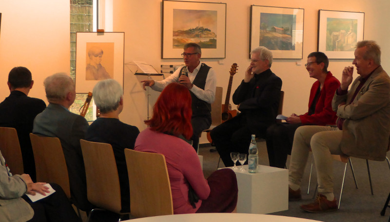 Auf dem Podium im Bad Honnefer Kunstraum  - v. l. Donatus Weinert (Liedermacher und Illusionist), Kunstpdagoge und Maler Karl-Heinz Hochstdt, Cornelia Nasner (Vorsitzende des Bad Honnefer Partnerschaftskomitees) und der deutsch-sorbische Schriftsteller Benedikt Dyrlich. Foto: Stadt Bad Honnef