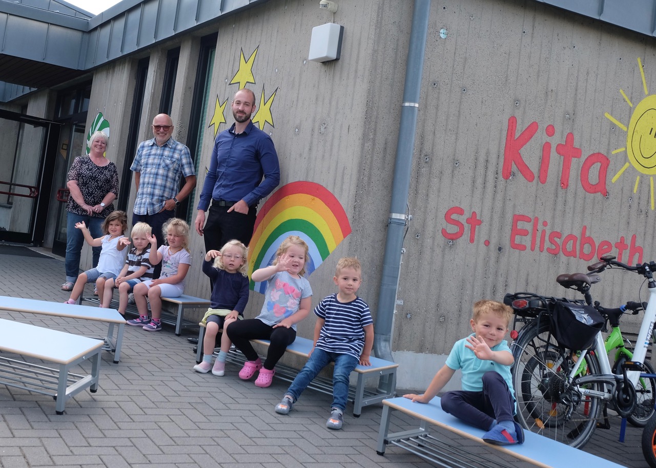 Auch die Kita-Kinder freuen sich ber die neuen tollen Garderoben-Sitzbnke. Hinten von links: Kita-Leiterin Susanne Gockel, Ortsbrgermeister Hubert Wagner und Daniel Demmer von Optirent. (Foto: KathaBe)  