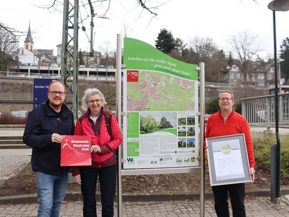 Am Start- und Zielpunkt (Bahnhof Kirchen), vor der neuen Portaltafel zu den Kirchener Rundwanderwegen, freuten sich Brgermeister Andreas Hundhausen, Barbara Sterr vom WanderTourenTeam Rengsdorf und Tourismusmanager Sven Wolff der Stabsstelle fr Vereine, Ehrenamt und Touristik gemeinsam ber die offiziell verliehene Zertifizierungsurkunde des Deutschen Wanderverbandes.