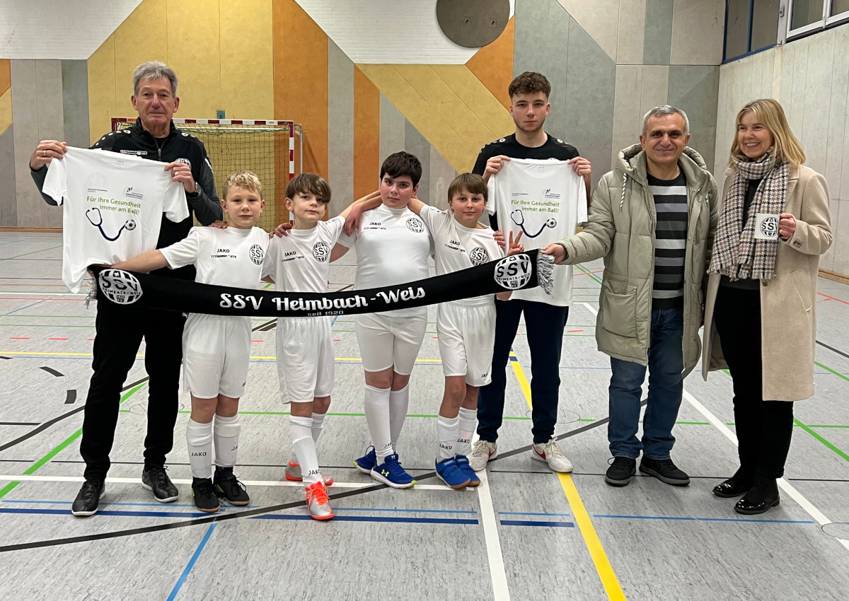 (v.l.n.r.) Martin Mllmeier, Cheftrainer U11-Junioren und motivierte Kicker der U11 bedanken sich bei Initiator und Spielervater Osama Hadad, Arzt im Herz-Jesu-Krankenhaus und der Kaufmnnischer Direktorin des Krankenhauses, Carmen Elschner, fr die neuen Trikotsets. (Foto: Martin Reuschenbach, Dernbacher Gruppe Katharina Kasper)