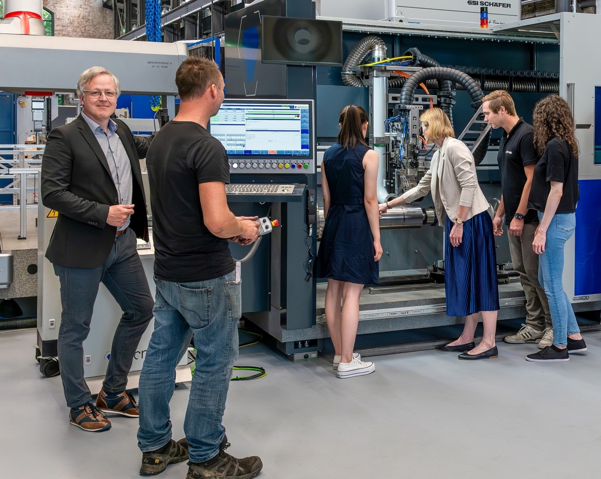 Prof. Dr.-Ing. Axel von Hehl (ganz links) ist der Siegener Sprecher des Graduiertenkollegs. Hier bei der Vorstellung einer sogenannten Laser Metal Deposition-Anlage, die auch bei der Forschung an "Circular E-Cars" zum Einsatz kommen wird. (Foto: Uni Siegen)