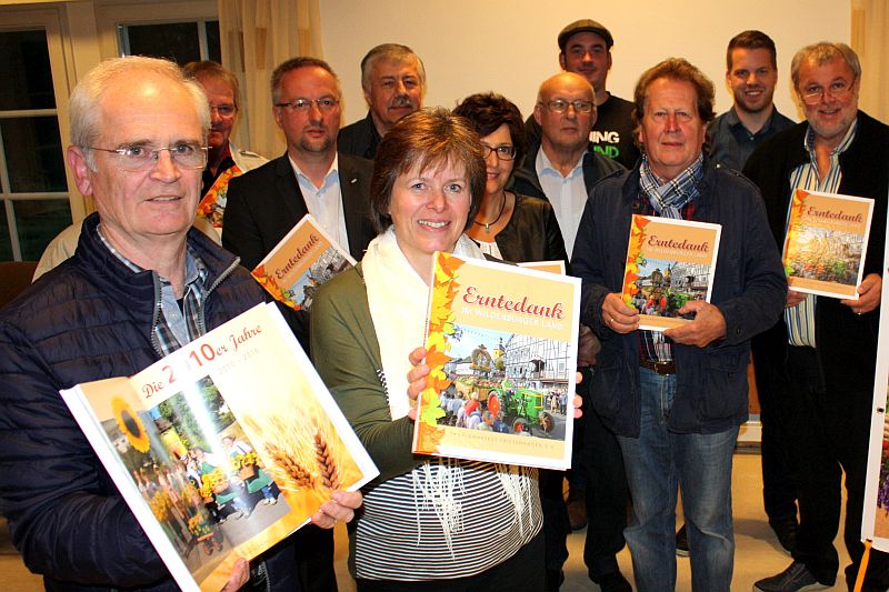 Hermann-Josef Schuh (vorne links) und Vorstandsvorsitzende Angelika Quast (vorne rechts) prsentieren zusammen mit den Vereinsmitgliedern und Helfern das Buch "Erntedank im Wildenburger Land" zum 50-jhrigen Jubilum Foto: jkh