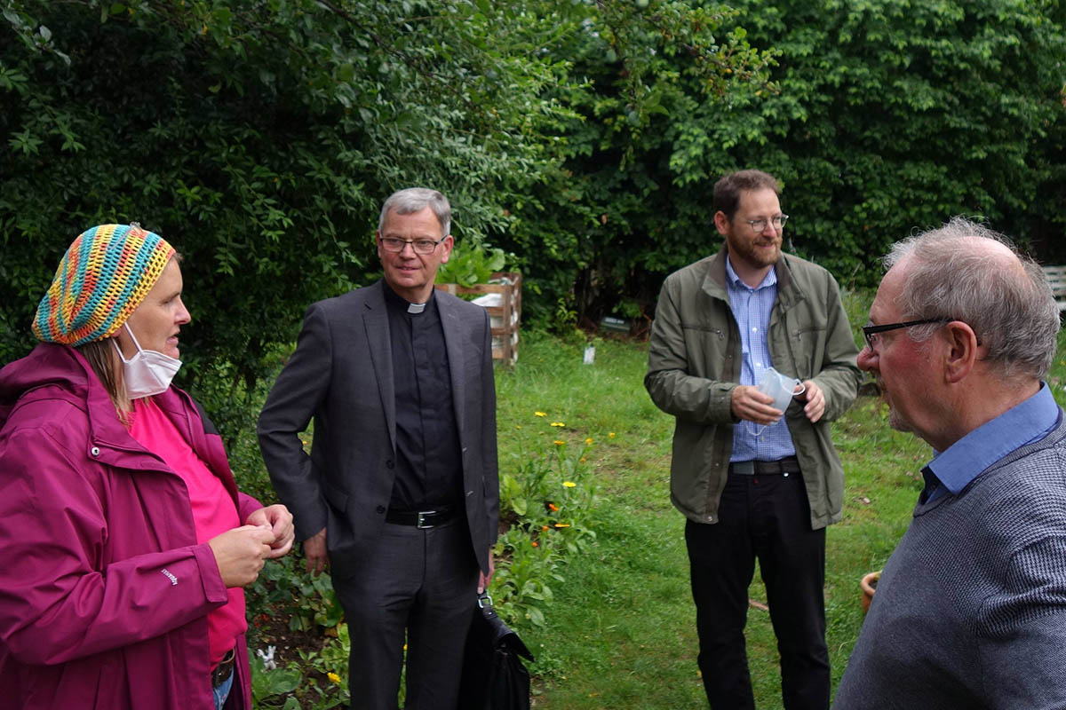 Die Ehrenamtliche Tina Monzen, Dechantenkooperator Oliver Seis (Zweiter v. rechts) und Josef Freise vom Koordinationsteam (rechts) zeigen dem Trierer Generalvikar (Zweiter v. links) die Grten rund um Heilig Kreuz. Foto: Julia Frder/Bistum Trier