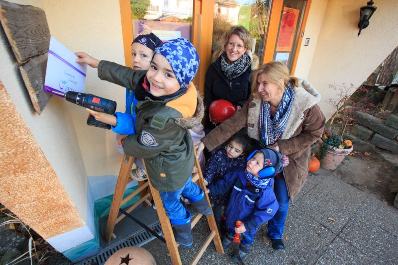 Die Kinder der Evangelische Kindertagessttte Hhr-Grenzhausen befestigen das Beta-Gtesiegel; Pfarrerin Monika Christ (hinten links) und Leiterin Petra Menne-Grtner helfen mit. Foto: Peter Bongard