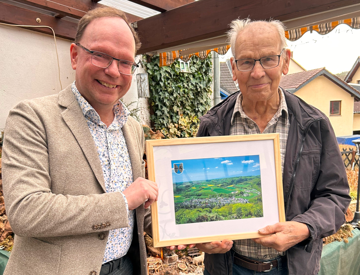 Ortsbrgermeister Thomas Boden (links) bergab Hermann Josef Mller (rechts) zur Verabschiedung ein Panoramabild von Robach. (Foto: privat)