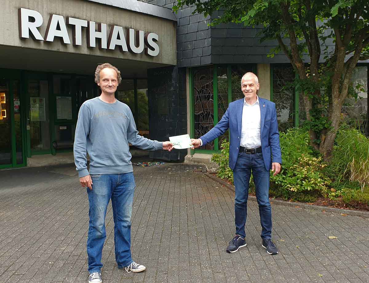 Brgermeister Fred Jngerich (rechts) berreicht Edwin Hess (links) einen Gutschein. (Foto: VG AK-FF)