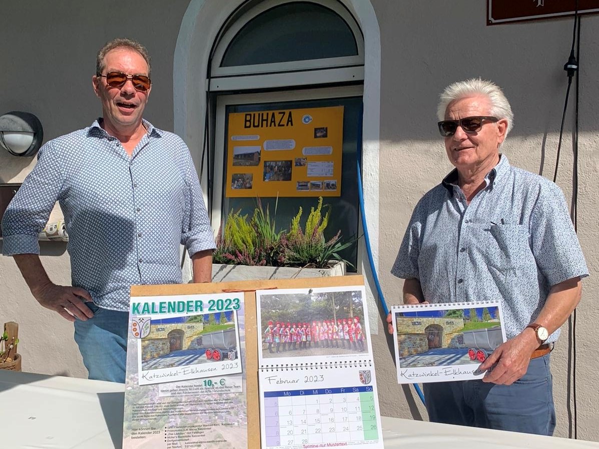 Ernst Dornhoff und Roderich Hfer prsentieren den neuen Heimat-Kalender 2023 auf dem Bazar der katholischen Jugend in Elkhausen. (Foto: privat)