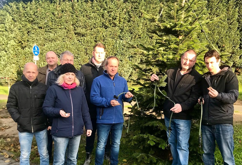  Vorstandsmitglieder der Aktionsgemeinschaft vor einem Weihnachtsbaum dessen Leuchtmittel fast vollstndig entwendet und auf dem nahen Radweg zerdeppert wurden. Extra aus Essen war der junge Syrer, Loutfi Rezek (rechts im Bild), am Wochenende angereist um wieder bei der Weihnachtsbaumaktion zu helfen. (Foto: Aktionsgemeinschaft)