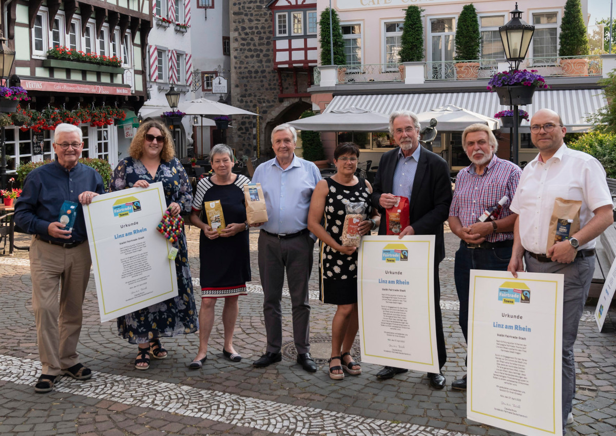 Am Strnzerbrunnen auf dem Burgplatz prsentierte Stadtbrgermeister Dr. Hans-Georg Faust zusammen mit der Leiterin der Tourist-Info, Janine Petit, und den Mitgliedern der Fair Trade Steuerungsgruppe Linz, die Urkunde, die der Stadt Linz von Fairtrade Deutschland aus Anlass der Titelerneuerung "Fairtrade-Stadt Linz am Rhein" berreicht wurde. (Foto: CREATIV PICTURE Heinz-Werner Lamberz)