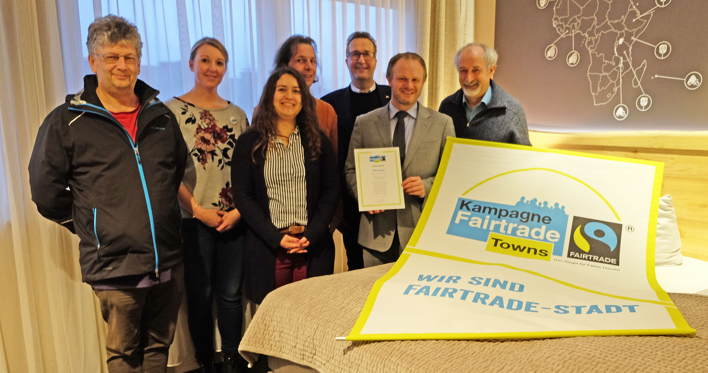 Im speziell gestalteten Fairtrade-Themenzimmer des food hotels freut sich die Steuerungsgruppe der Stadt Neuwied ber die Titelverlngerung (von links): Thomas Schmidt, Alena Linke, Julia Wiederstein, Thorsten Klein, Jrg  Germandi, Oberbrgermeister Jan Einig und Wolfgang Rahn. Foto: Stadt Neuwied