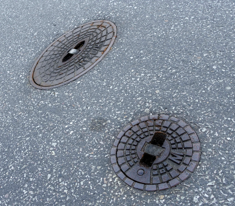 Diese Kappen kennt man. Unter den runden befinden sich die Schieber, um das Wasser abzustellen. Die ovalen sind fr Hydranten. Fr den Check der Wasserleitungen mssen die Prfer sie ffnen. Foto: SWN