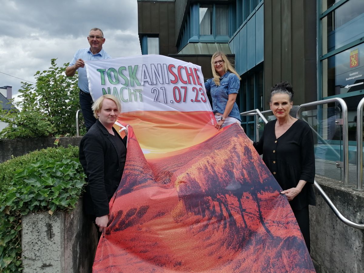 Auf dieser extra angefertigten Fahne sollen Unterschriften aller Teilnehmer verewigt werden. Ralf Lindenptz (hinten links), Petra Schwarzbach (hinten rechts), Bastian Prie und Cordia Heck werben fr die Toskanische Nacht. (Foto: vh)  