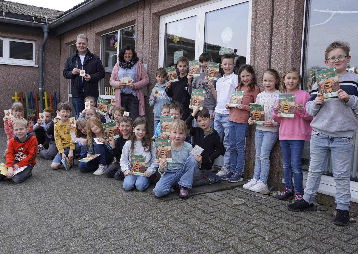 Brgermeister Gerrit Mller bergab die Blumensamen und Kinderbcher an Schulleiterin Carina Ludwig und die "Kleinen Bienenretter" an der Grundschule Hoher Westerwald in Nister-Mhrendorf. (Foto: Kerstin Guckert)