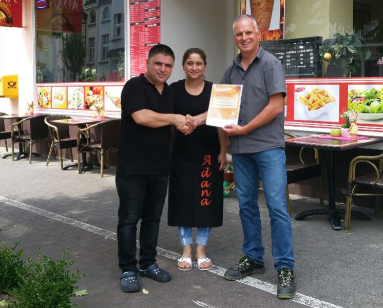 Die Beetpaten bekommen fr die Pflege eine offizielle Urkunde der SBN. Auch das Ehepaar Adana, das eine bunte bepflanzte Baumscheibe vor dem Geschft pflegt, erhielt von Thomas Riehl (r.) eine Urkunde. Foto: privat