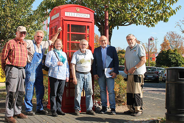 Es ist vollbracht. Kurt Hecken, 2. v. l. und Guido Job, 2.v. r. freuen sich gemeinsam mit den aktiven Senioren ber das gelungene Werk der restaurierten englischen Telefonzelle. Foto: TI VGV Bad Hnningen