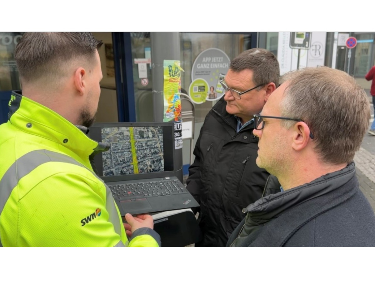 Gemeinsam fr eine vernetzte Innenstadt: Calvin Herpel von den SWN (links) prsentiert Oberbrgermeister Jan Einig (Mitte) und Stefan Herschbach (rechts), Geschftsfhrer SWN, den ersten Standort des neuen kostenlosen WLANs. (Foto: Melanie Lange)