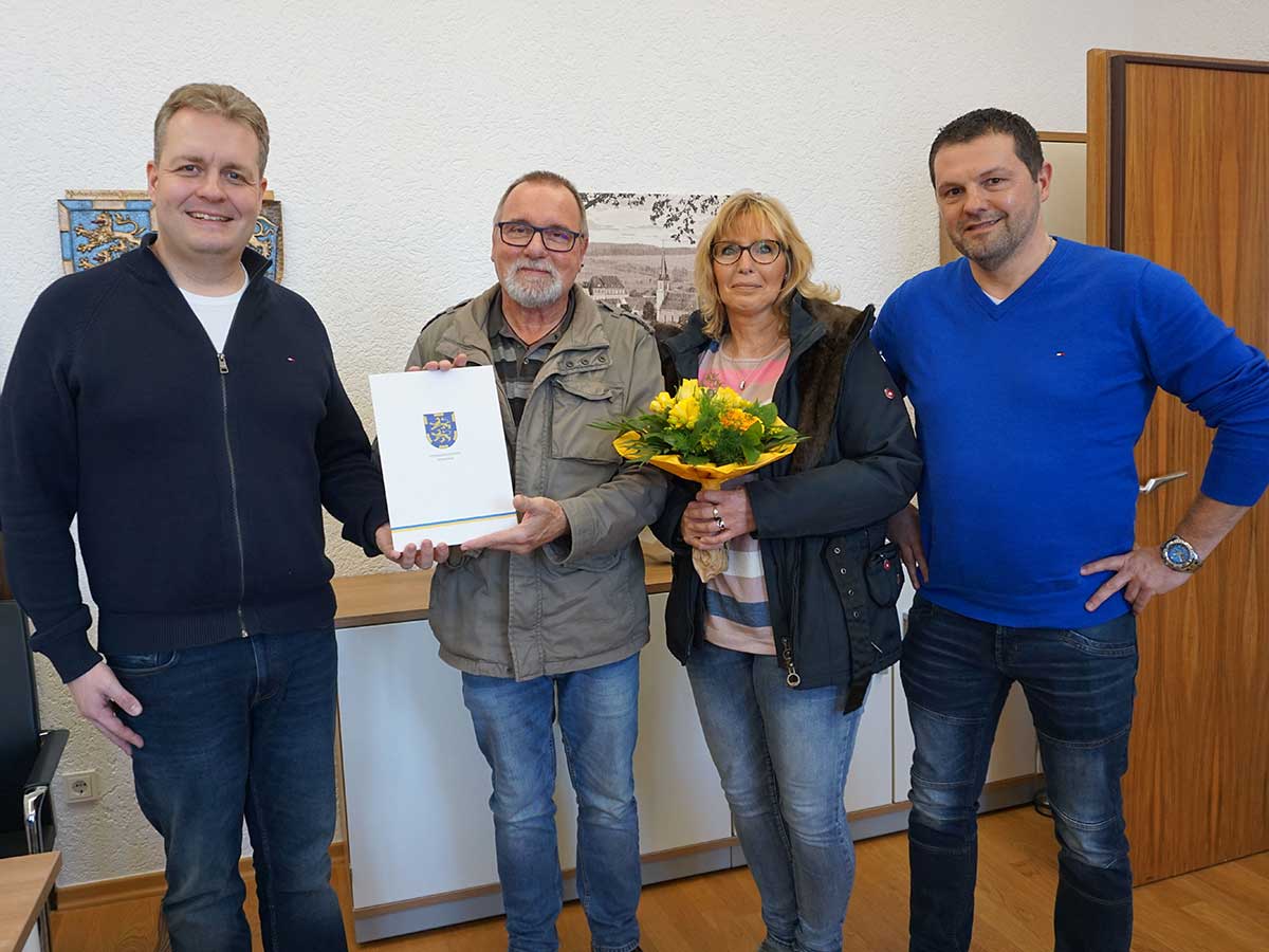 Brgermeister Gerrit Mller berreicht gemeinsam mit Abteilungsleiter Markus Schmiedl den 100. Frderbescheid fr ein Balkonkraftwerk an die Eheleute Ralf und Kerstin Helsper aus Hellenhahn-Schellenberg. (Foto: Kerstin Guckert, Verbandsgemeindeverwaltung)