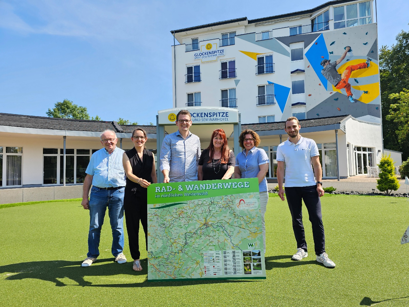 Eine Outdoor-Rad- und Wanderkarte der Verbandsgemeinde Altenkirchen-Flammersfeld berreichten Beigeordneter R. Schmidt-Markoski (links) und die Touristikerinnen Susanna Mokro, Martina Beer und Angela Metzen (v.l.) an Hoteldirektor Paul Daniel (3.v.l.) und Marketing Manager Jakob Pfeifer (rechts). (Foto: Michael Isaak)