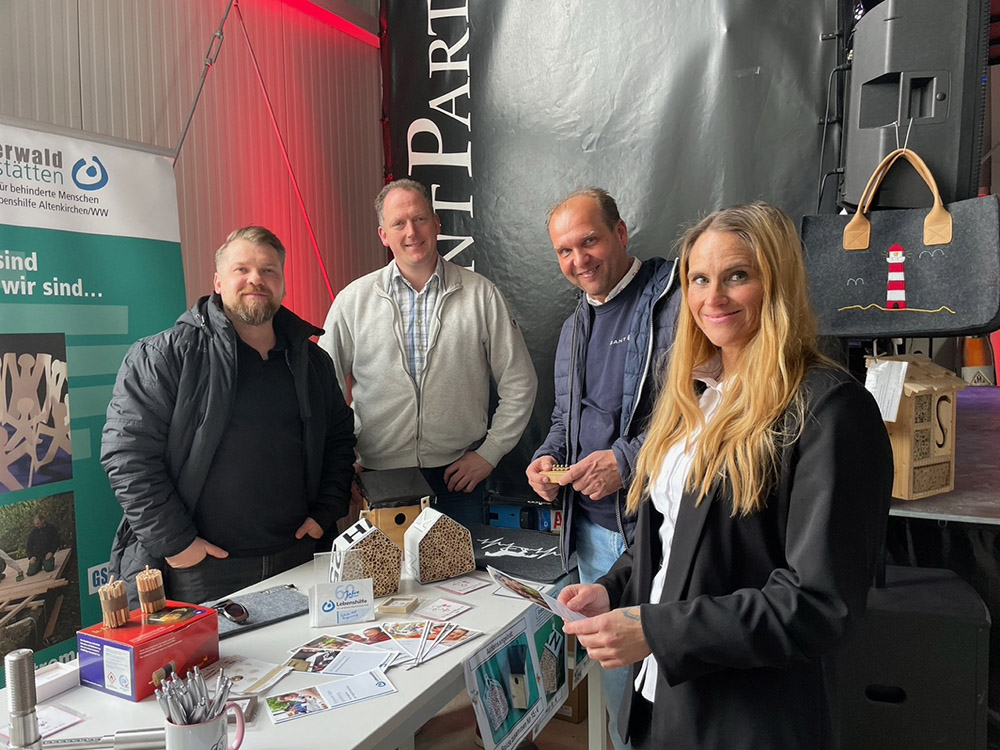 Die Westerwald-Werksttten der Lebenshilfe prsentierten sich zur Jubilumsfeier mit einem Stand. Von links: Konstantin Dortmann und Michael Schfer mit Thomas Broschk und Martina Seel. (Foto: KathaBe)