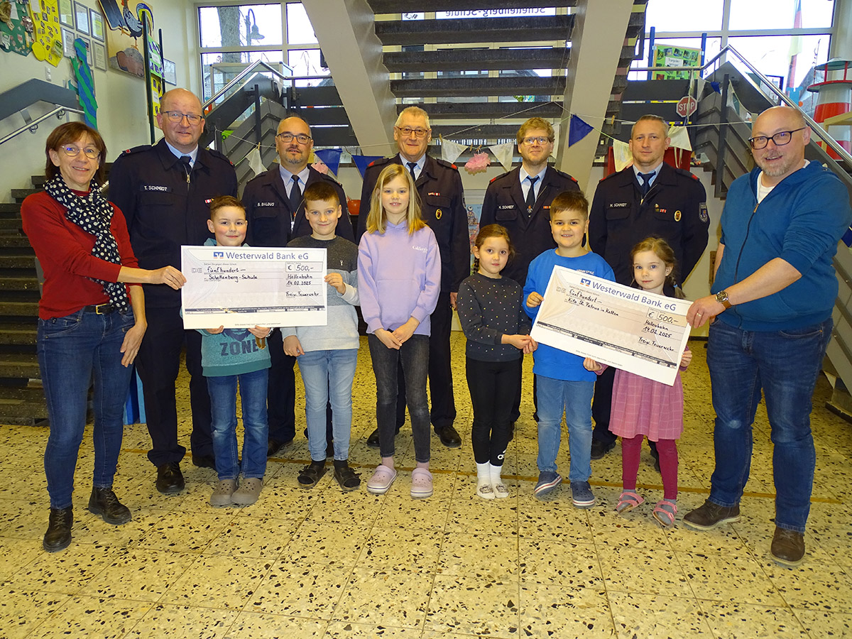 Symbolische Spendenschecks berreichten Vorstandsmitglieder der Freiwilligen Feuerwehr
(hinten v.l.: Thorsten Schmidt, Boris Baldus, Hubert Schmidt, Marius Schmidt, Matthias Schmidt) an die Leiterin der Schellenberg-Grundschule Anja Pfeil-Stickel (links) und den Leiter der Kita Christoph Wenzel (rechts). Strahlende Kinderaugen begleiten die Aktion. Foto: Willi Simon