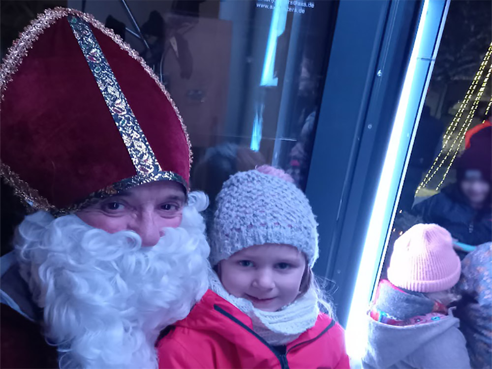 Ohne Scheu nahmen die Kinder auf dem Scho vom Nikolaus Platz. Eine 100-kpfige Kinderschar drngten sich auf dem Weg zum Heiligen Nikolaus. Fr alle gab es eine reichlich gefllte Nikolaustte. Fotos: Willi Simon