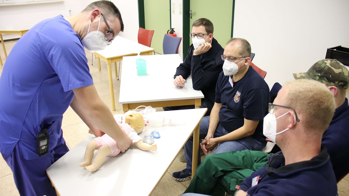 Fachgesundheits- und Kinderkrankenpfleger fr Intensivpflege und Ansthesie Patrick Reimann (links) leitet Krfte der Freiwilligen Feuerwehr Herdorf im Umgang bei einem Notfall mit einem Kleinkind an. (Fotos: privat)