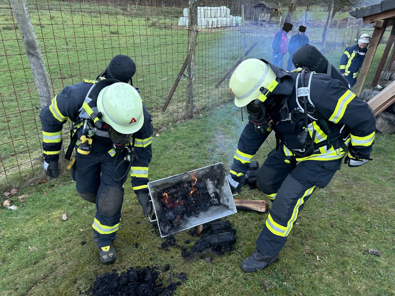 Brandgut aus dem Kamin wird unter Atemschutzmasken aus dem Keller gebracht. (Alle Fotos: Feuerwehr Hamm)