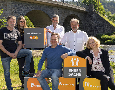 Ulrich Botsch (hinten, Mitte) bergibt den Spendenbetrag zusammen mit dem Brgermeister der Verbandsgemeinde, Peter Klckner (hinten rechts), an Vertreter der begnstigten Vereine. Zustzlich zu der Geldspende gibt es neue EVM-Sitzwrfel. (Foto: EVM) 