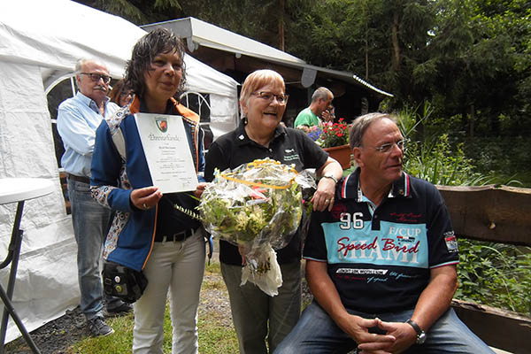 Sonja und Wilhelm Lenz berraschten Heidi Biermann bei der Veranstaltung "Tag der offenen Tr" auf dem Vereinsgelnde in Obersteinebach. Auf dem Foto vorne v.l.n.r.: Sonja Lenz, Heidi Biermann, Wilhelm Lenz. Foto: Angel- und Naturschutzverein Neustadt/Wied e.V. Foto: pr
 
