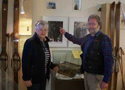 Heide Wahl und Museumsleiter Achim Heinz vor einem Portrt und den Originalskiern des Wintersportpioniers Siegfried Koch. Foto  Bergbaumuseum des Kreises Altenkirchen