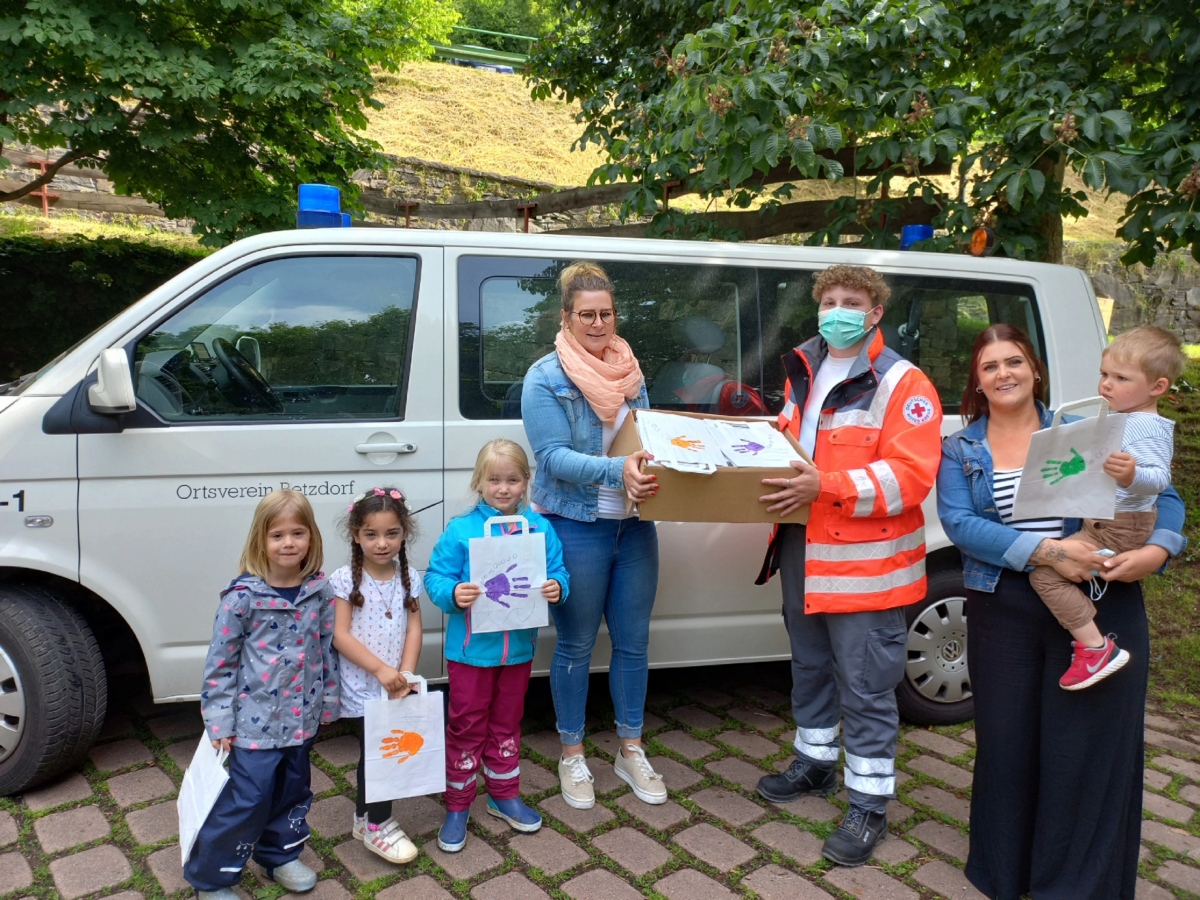 Die Erzieherinnen Jacqueline Lanfer und Marina Budweg bergaben mit einigen Kinder stolz die liebevoll angemalten Tten an Dominik Ketzer vom DRK-Ortsverein Betzdorf. (Foto: Kita)