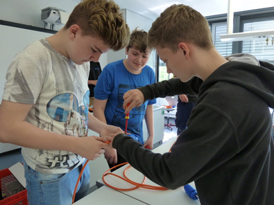 Drei motivierte Schler montieren ein Verlngerungskabel, welches sie spter mit nach Hause nehmen durften. Fotos: Schule