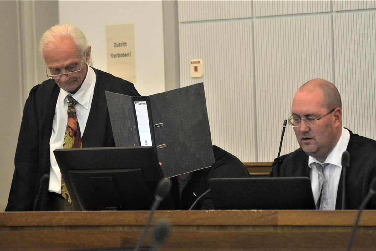 Beim Prozessauftakt am Koblenzer Landgericht versteckt der Angeklagte sein Gesicht hinter einem Aktenordner. Foto: Wolfgang Rabsch