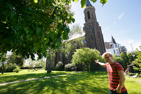 Auf dem Bild sieht man die Pauluskirche und Pfarrer Maurice Meschonat, der zeigt, wo das neue Zentrum entstehen soll. Foto: Evangelisches Dekanat Westerwald