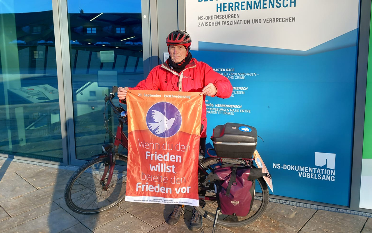 Hermann Reeh nimmt auf seine Touren immer die Friedensfahne mit, hier an der Burg Vogelsang. (Fotos: Reeh)