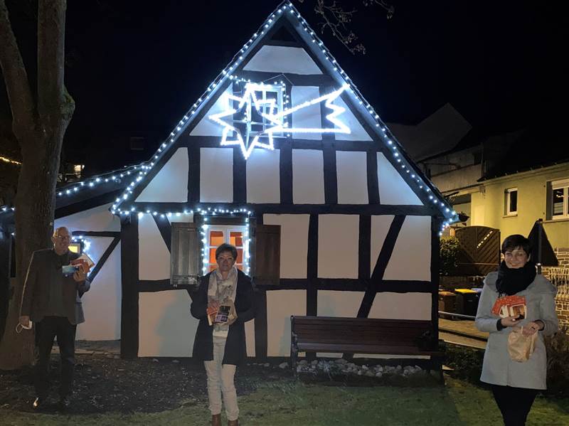 Ratsmitgliederinnen Simome Hachenberg und Karina Sahm nach dem Ttenpacken am weihnachtlich beleuchteten Glockenhaus mit Ortsbrgermeister Michael Wschenbach. (Foto: Gemeinde)